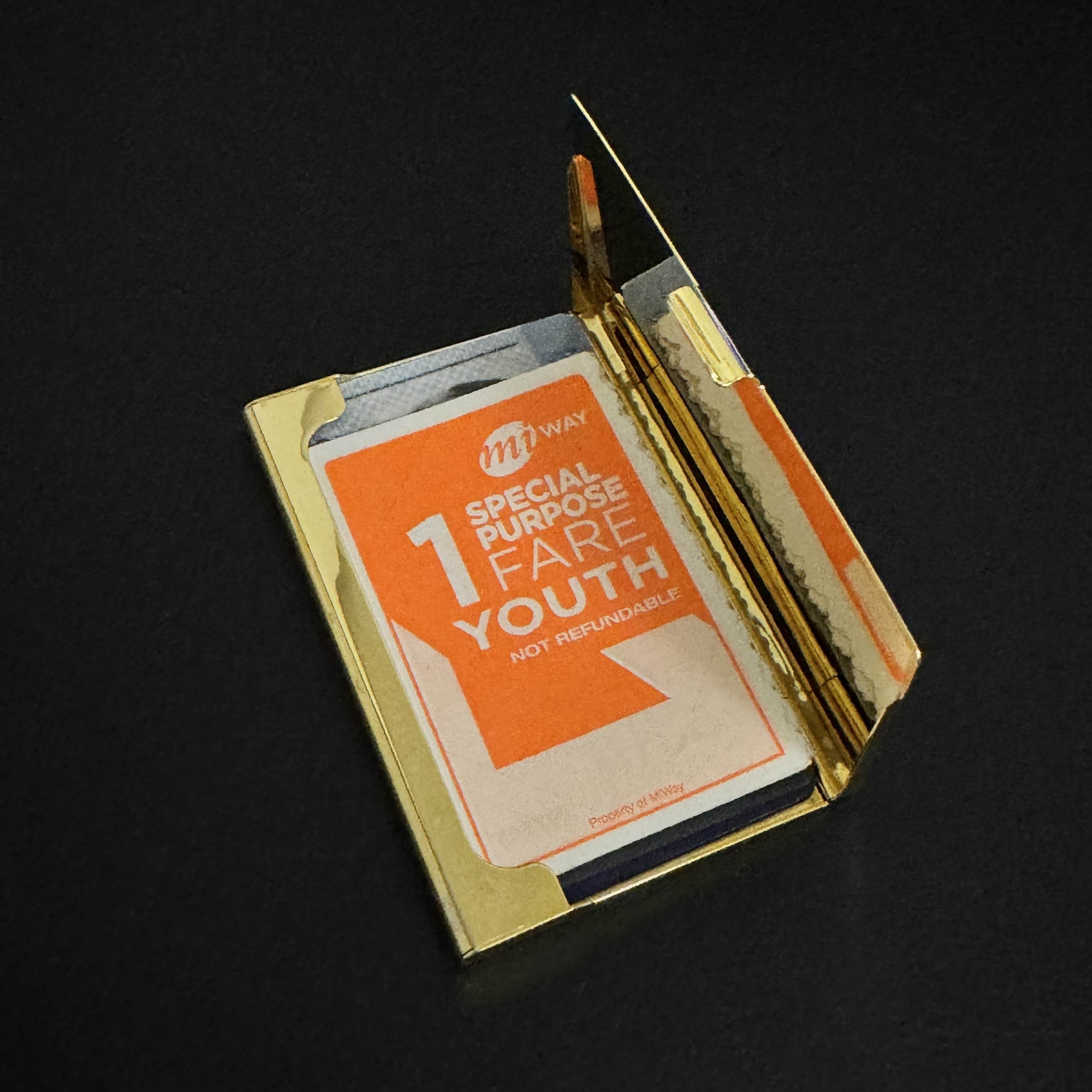 The tab on this card holder provides the affordance of opening and closing the holder to the user. It's more visible in the previous photo, but the tab actually juts out quite a bit to provide more surface area to quickly push open the tab with just a flick of the finger.