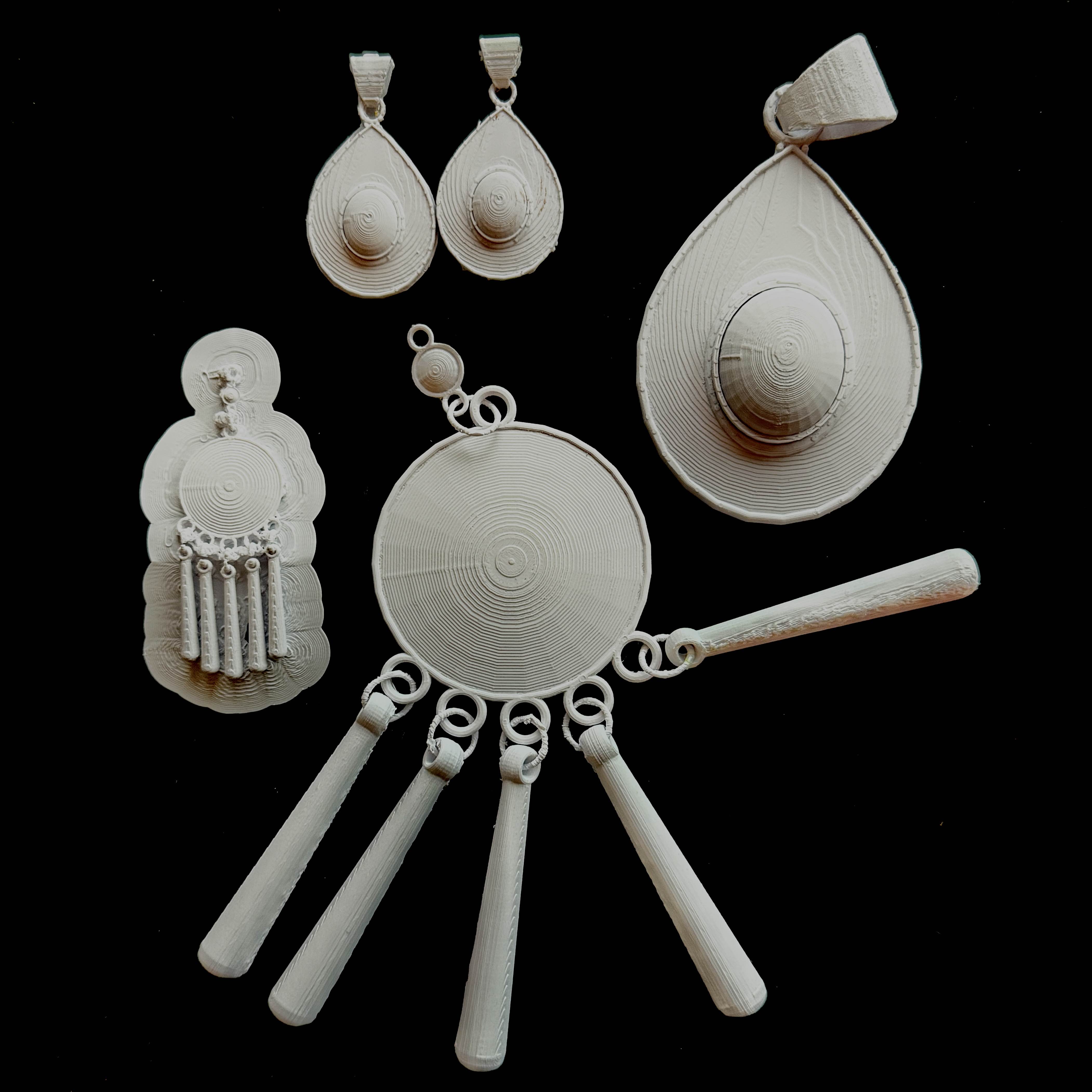 A photo of my final, 3D printed project. I included my progress work in the photo, not only because it shows my progress, but also because it made for a more intersting photo composition. The dangling aspects on the larger, final prints (the clasp of the pendant and the chains on the shashtenge) are fully functional, as can be seen by their posing.