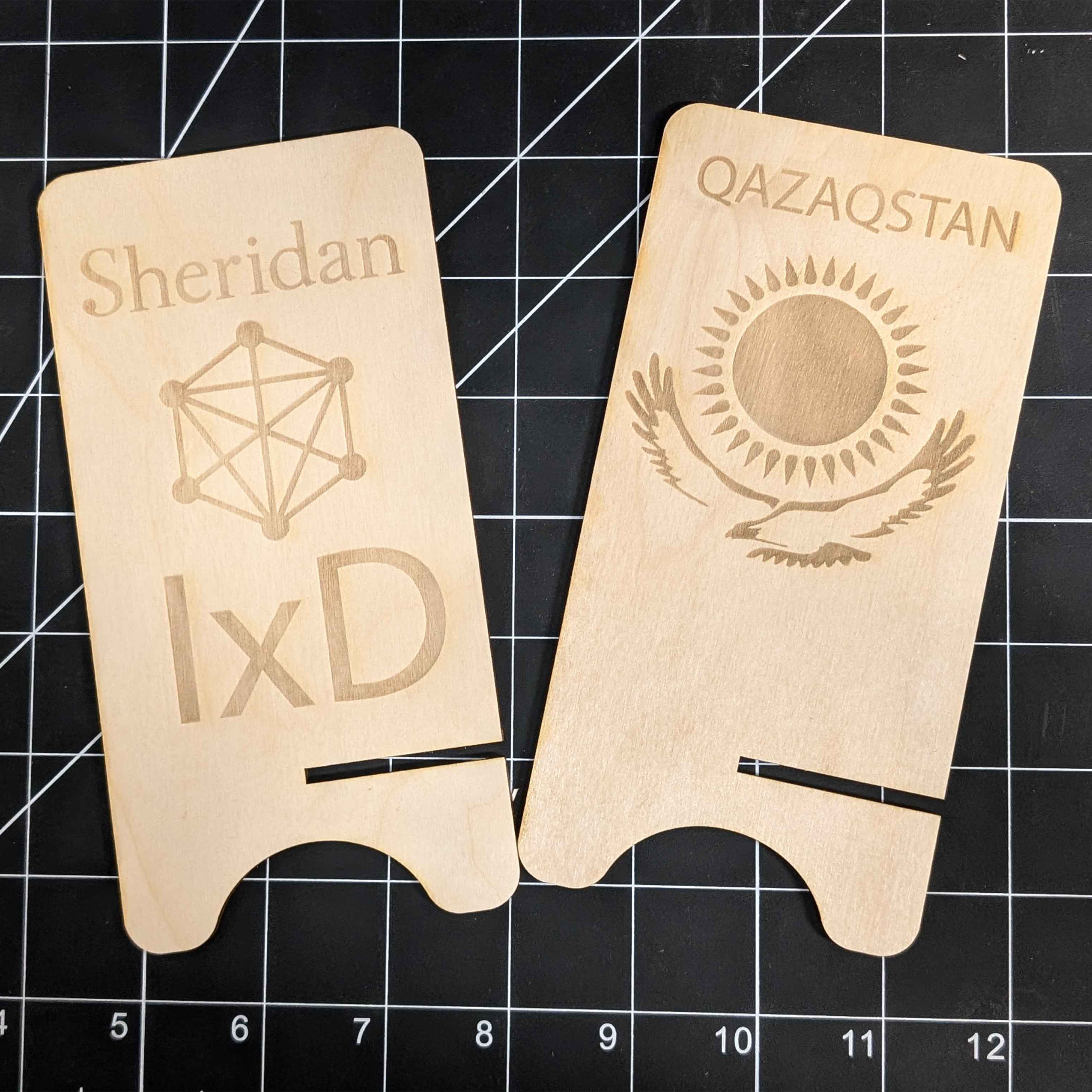 Sheridan IXD and Qazaq flag phone stand face pieces side by side. I wish I put the Qazaq design lower down on the wood face.
